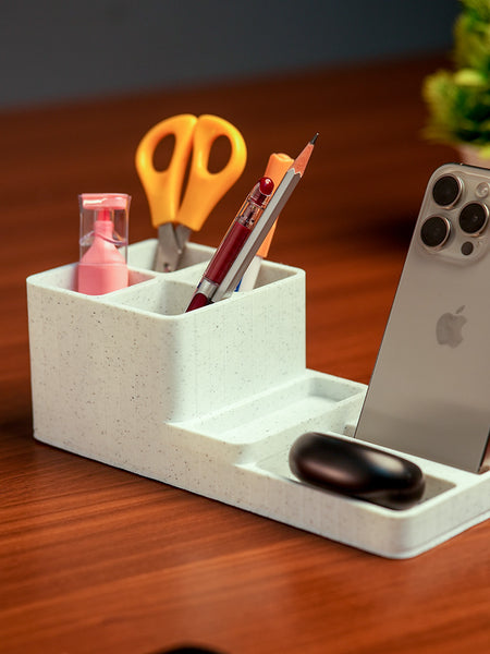 White desk organizer with phone stand, pens, scissors, and other items on a wooden surface.