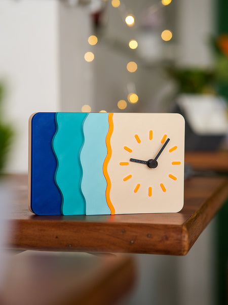 Colorful clock with wavy design on a wooden surface, blurred indoor background