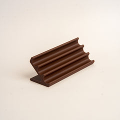 Wooden pen holder with three pens on a beige background