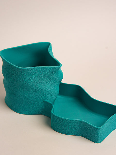 Teal textured planter with matching tray on a beige background