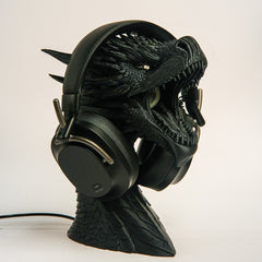 Black gaming headset on a detailed black stand against a white background