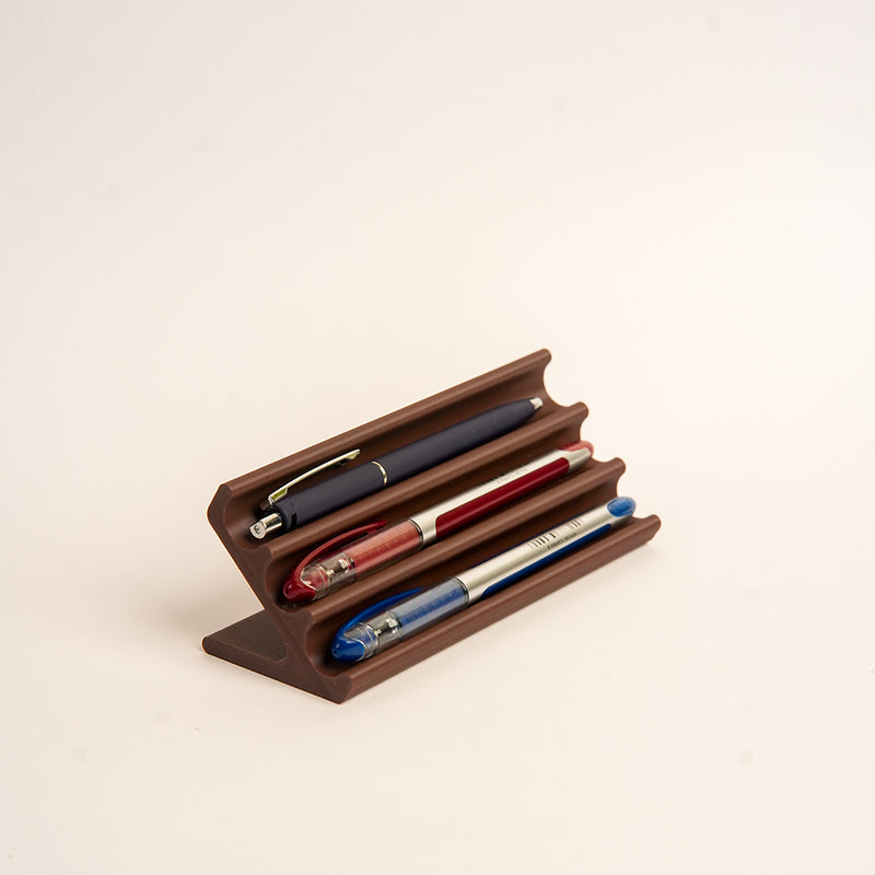 Wooden pen holder with three pens on a  white background