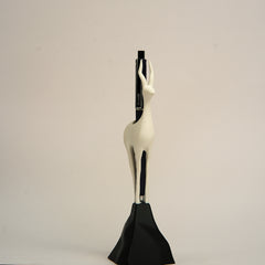 Decorative sculpture of a woman with a black base on a beige background