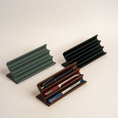 Three pen holders in different colors on a light background