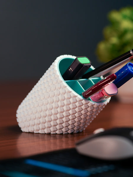 White textured pen holder with pens on a desk