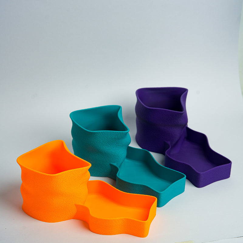 Turquoise desk organizer with scissors, pen, and black object on a wooden surface.