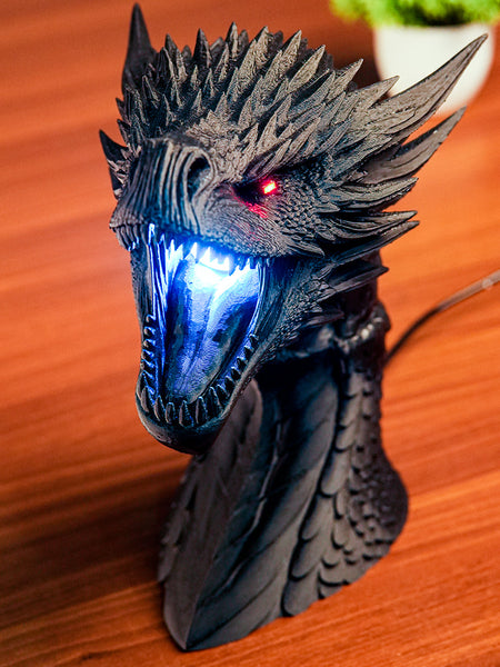 Dragon head sculpture with LED lights on a wooden surface