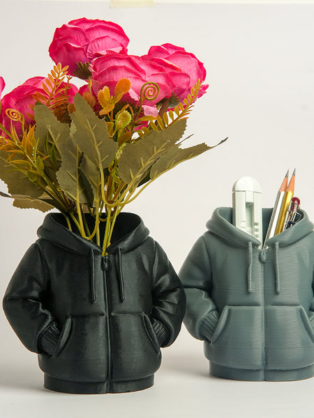 Two hoodie-shaped planters with flowers and stationery on a white background