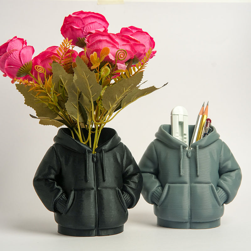 Two hoodie-shaped planters with flowers and stationery on a white background