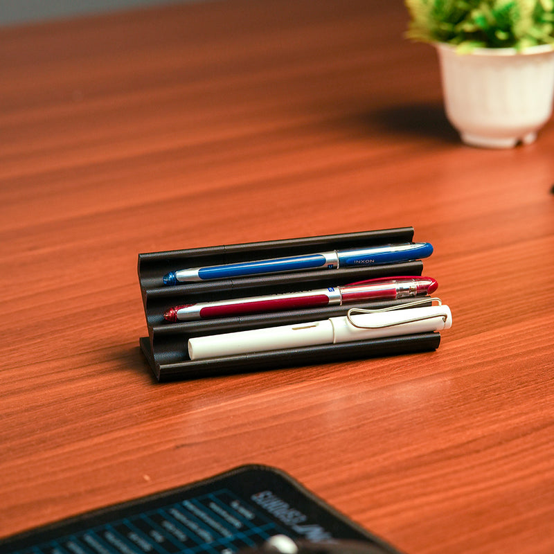 Wooden pen holder with three pens on a beige background