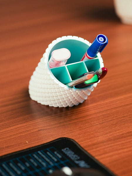 Shell-shaped organizer with stationery items on a wooden surface