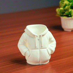 Black hoodie-shaped pen holder with stationery items on a light pink background