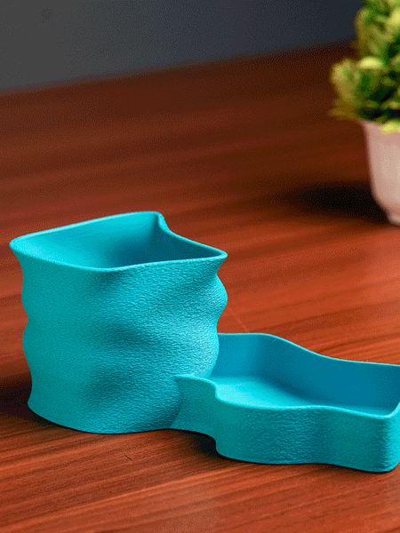 Teal pen holder with stationery items on a light background
