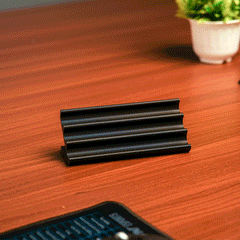 Wooden pen holder with three pens on a beige background