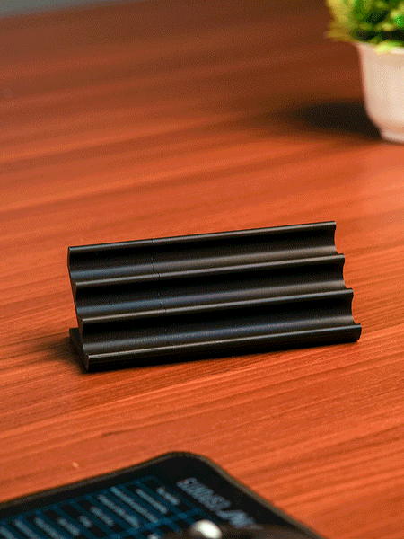 Wooden pen holder with three pens on a beige background