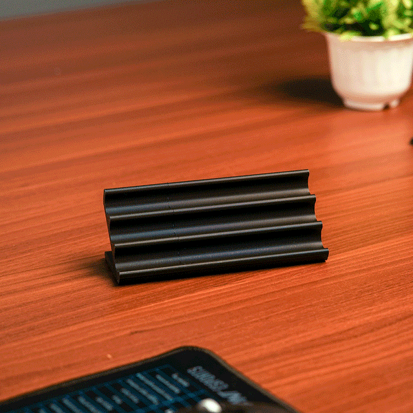 Wooden pen holder with three pens on a beige background